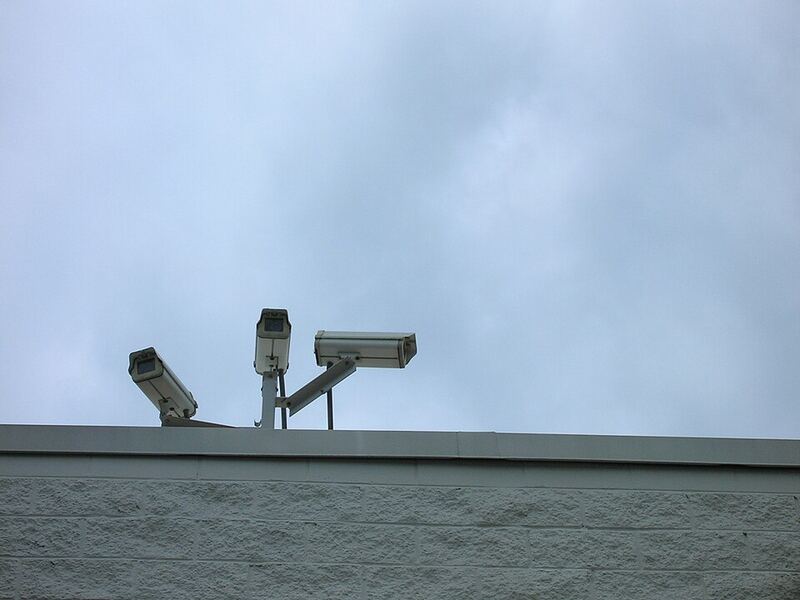 Bullet CCTV cameras mounted on a factory roof edge covering the perimeter